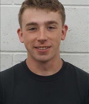 Picture of male employee Brandon Conn in front of white wall.