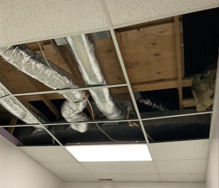 A picture of a ceiling all opened due to leakage of an AC unit. 