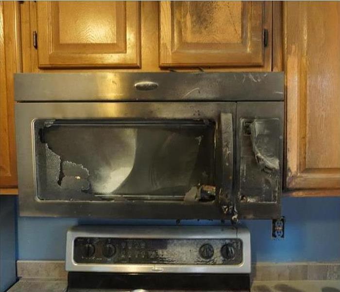 A microwave burnt to a crisp after a stove top fire.